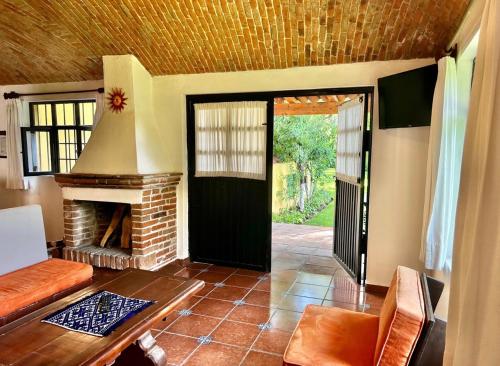 a living room with a fireplace and a black door at Quinta Los Vela in Tequisquiapan