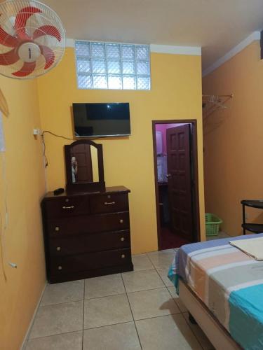 a bedroom with a bed and a dresser with a mirror at Fragata in Puerto Baquerizo Moreno
