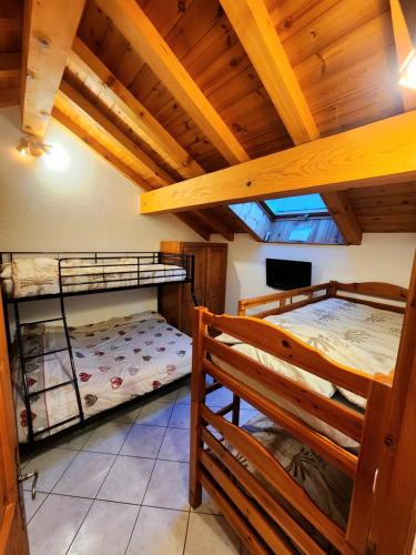deux lits superposés dans une chambre avec plafond en bois dans l'établissement Chalet Pascal, à Valloire