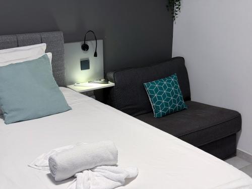 a bedroom with a bed with a chair and a pillow at D' Suites Holiday Apartments in Il-Gżira