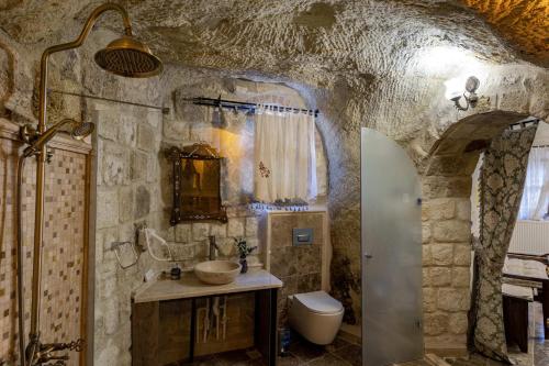 a stone bathroom with a sink and a toilet at Keyf i ala capadocia in Ürgüp