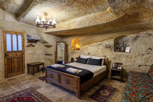 a bedroom with a bed in a stone room at Keyf i ala capadocia in Ürgüp