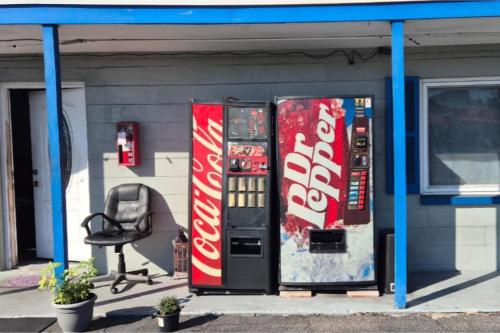 two cocacola machines sitting outside of a gas station at Base Motel By OYO South Tampa in Tampa