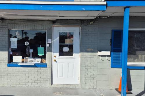 a store front with a white door and a window at Base Motel By OYO South Tampa in Tampa