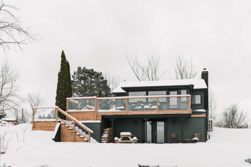 een huis met een terras in de sneeuw bij Narrows Nook - Prince Edward County Waterfront in Deseronto