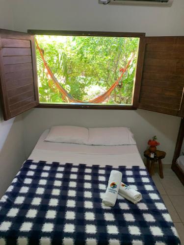 a bed in a small room with a window at The Beach Hostel Milagres in São Miguel dos Milagres