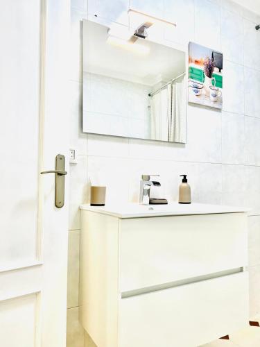 a white bathroom with a sink and a mirror at Tineo centro in Tineo