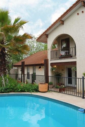 a villa with a swimming pool in front of a house at Lakehouse Bed and Breakfast in Canyon Lake