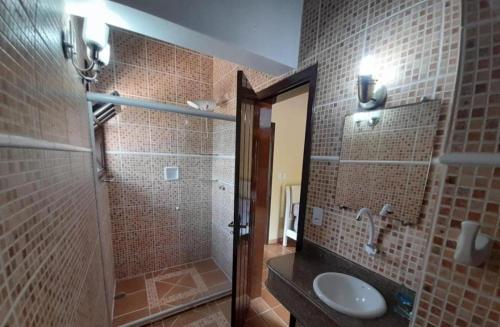 un bagno con doccia, lavandino e WC di Casa em Peruíbe com piscina a Peruíbe