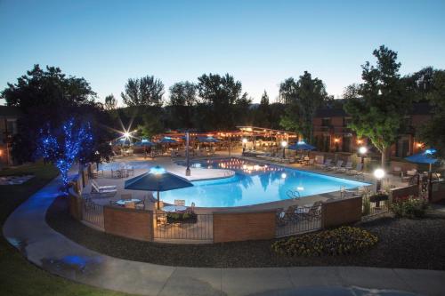 a large pool with tables and umbrellas at night at Riverside Hotel, BW Premier Collection in Boise