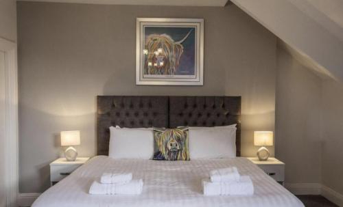 a bedroom with a large bed with two lamps at The Alexander in Whitley Bay