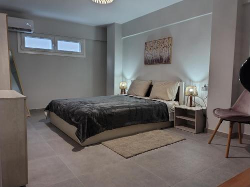 een slaapkamer met een bed, een tafel en een stoel bij Konstantinos Loft in Serres