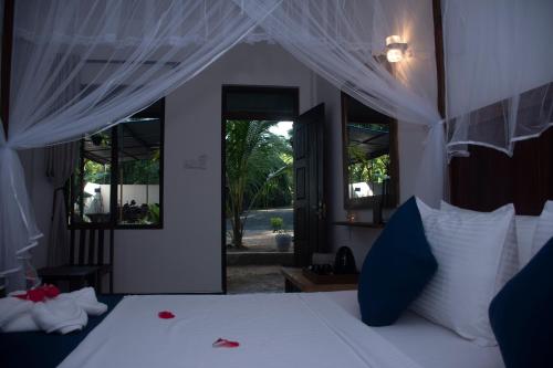 a bedroom with a white bed with a canopy at Coco Villa Udawalawe in Udawalawe