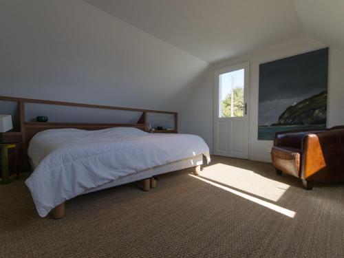 una camera da letto con un letto, una sedia e una finestra di Maison récente 4 chambres, vue mer, jardin, 8 pers - FR-1-418-13 a Locmaria