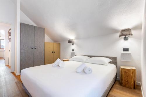 ein weißes Schlafzimmer mit einem großen Bett mit weißen Kissen in der Unterkunft Hostdomus-La casa di Luna in Grange Sises