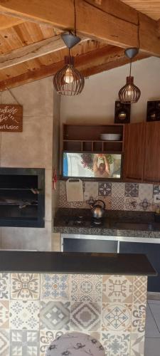 een keuken met een aanrecht met een tv en een open haard bij Lar doce lar in Bonito