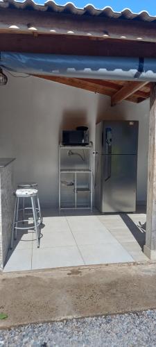 een keuken met een koelkast en een tafel onder een dak bij Lar doce lar in Bonito