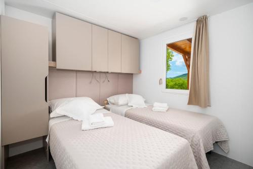 two beds in a room with a window at Mobile Home Kapo I Exclusive Mobile Home with Private Pool in Sitno Donje