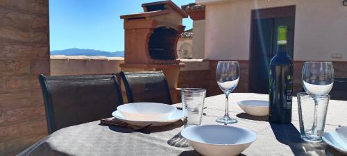 een tafel met een fles wijn en glazen erop bij El Balcón de Huéscar in Huéscar
