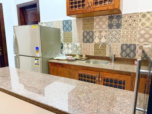 een keuken met een koelkast en een wastafel bij Bab Al Shams Palace in Luxor