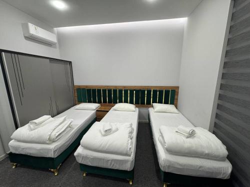 een kamer met drie bedden in een kamer bij Vivid in Sergeli