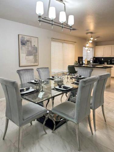 a dining room with a glass table and chairs at 3BR - 3BA w Pool & BBQ -15 Mins to Strip & Airport in Las Vegas