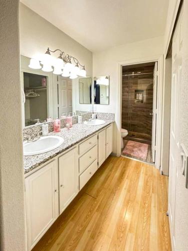 a white bathroom with two sinks and a mirror at 3BR - 3BA w Pool & BBQ -15 Mins to Strip & Airport in Las Vegas