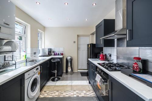 a kitchen with a washer and dryer at House - Sleeps 8 - Garden - Short Walk to Station in London