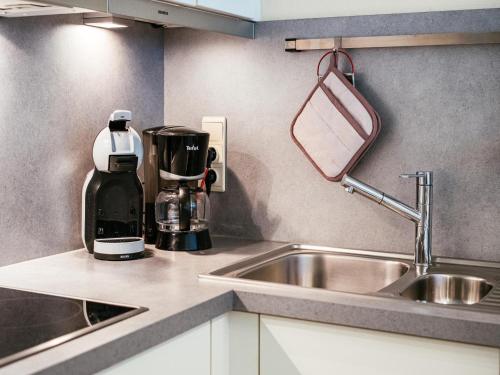 a kitchen counter with a coffee maker and a sink at Anais derde in Sint-Idesbald