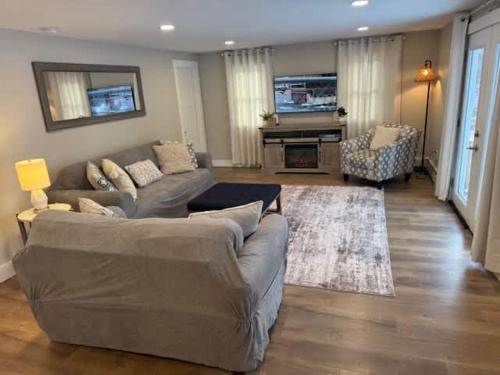 een woonkamer met een bank en een open haard bij Sebago Basin Getaway - An Unforgettable Experience in North Windham