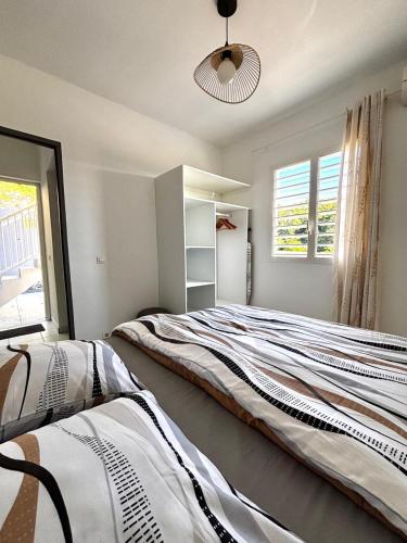 een slaapkamer met een groot bed en een raam bij La bulle D'Isma - Jacuzzi intimiste, proche plage in Le Gosier