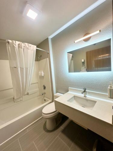 a bathroom with a sink and a toilet and a bath tub at Super 8 by Wyndham Warrenton in Warrenton