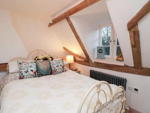 una camera da letto con un letto e una finestra di The Hare & The Bumblebee Cottage a Hoxne