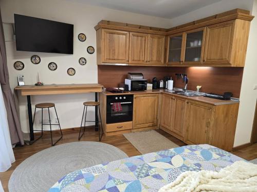 une cuisine avec des armoires en bois et un comptoir dans l'établissement Pirin Golf Cozy Studio, à Razlog