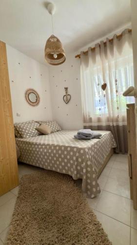 a small bedroom with a bed with polka dots at Fay's paradise in Polychrono
