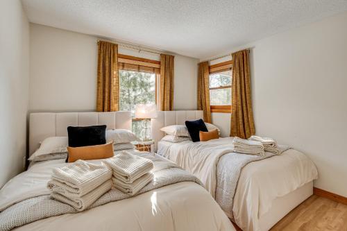 two beds in a room with two windows at Riverfront Lincoln Condo w/ Patio + Pool Access! in Lincoln