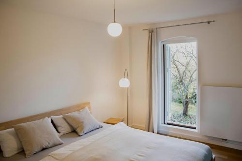 ein Schlafzimmer mit einem Bett mit einem großen Fenster in der Unterkunft Appartement mit Connection am Müritz- Nationalpark 