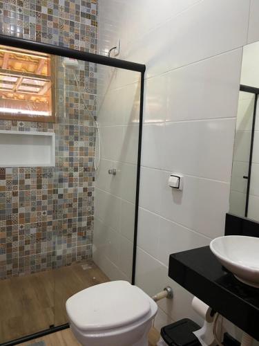 a bathroom with a toilet and a sink at Sítio Anna in São Thomé das Letras