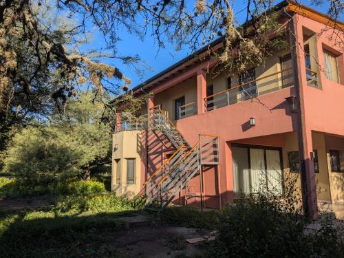 een roze gebouw met een trap ervoor bij Posada Abrazo Serrano en Carpintería in Carpintería