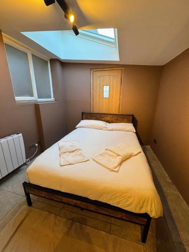 a bedroom with a bed with two towels on it at 4bedrooms house sleeps14 Garden&Parking Ably Stays in London