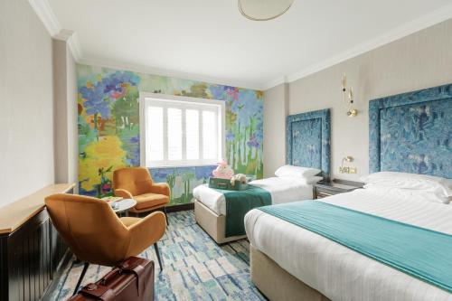 a hotel room with two beds and a window at Ashdown Park Hotel in Gorey
