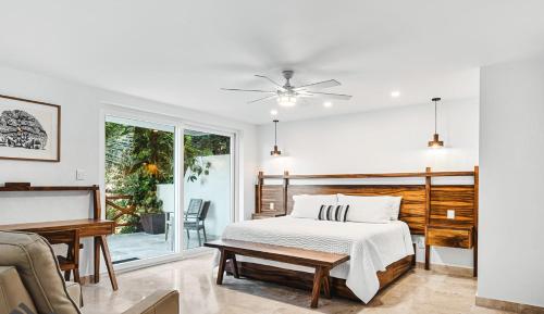 a white bedroom with a bed and a couch at Pájaro de Fuego 406 in Sayulita