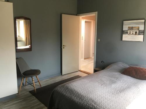 una camera con un letto, una sedia e una porta di Villa Svane a Rødby
