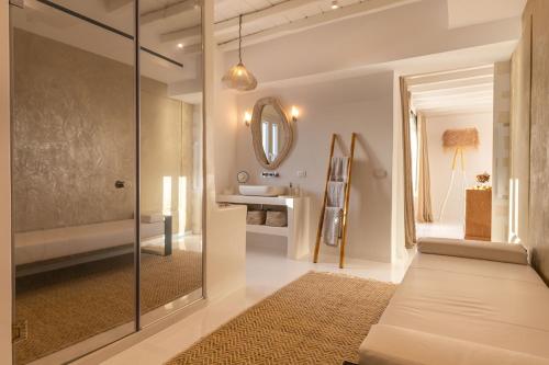a bathroom with a glass shower and a sink at Villa Macaro with Direct Beach Access in Mikonos