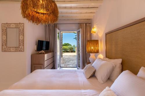 a bedroom with a large white bed with a view at Villa Macaro with Direct Beach Access in Mikonos