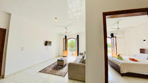 a bedroom with a bed and a couch and a mirror at Sun wing guest house in Luxor