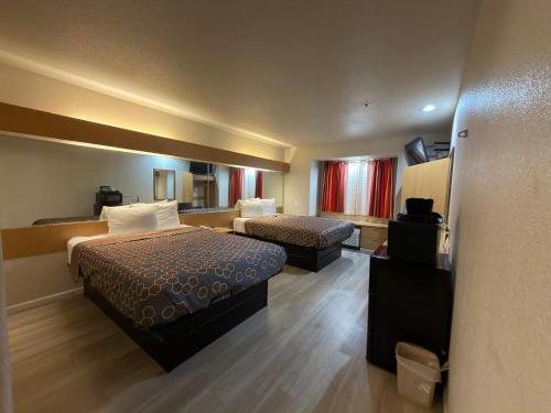 een hotelkamer met twee bedden en een televisie bij Americas Best Value Inn and Suites Ada in Ada