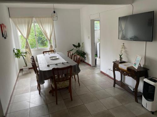 una sala da pranzo con tavolo, sedie e televisione di Altos Jujuy 2 a San Salvador de Jujuy