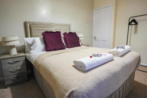 a bedroom with a large bed with towels on it at Victory House in Gretna