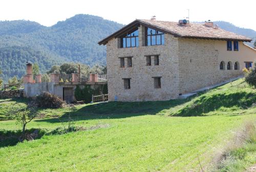 an old stone house on a grassy hill at Masia de la Serra de la Cogulla in Peñarroya de Tastavins